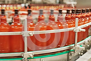 Plastic bottles with beer or carbonated beverage moving on conveyor