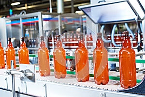 Plastic bottles with beer or carbonated beverage moving on conveyor