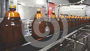 Plastic bottles for beer or carbonated beverage moving on conveyor. Shallow DOF. Selective focus.