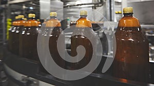 Plastic bottles for beer or carbonated beverage moving on conveyor. Shallow DOF. Selective focus.