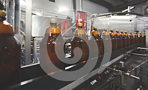 Plastic bottles for beer or carbonated beverage moving on conveyor. Shallow DOF. Selective focus.