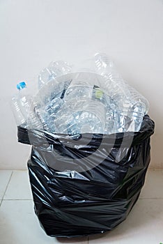 Plastic bottles in black garbage bags waiting to be taken to recycle.