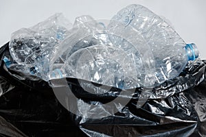 Plastic bottles in black garbage bags waiting to be taken to recycle.