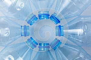 Plastic bottles on a blue background as a symbol of ecological catastrophes.
