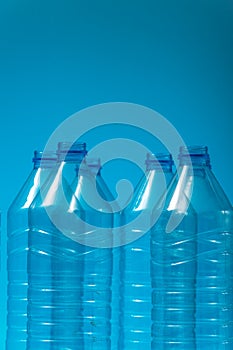 Plastic bottles on a blue background as a symbol of ecological catastrophes.