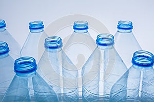 Plastic bottles on a blue background as a symbol of ecological catastrophes.