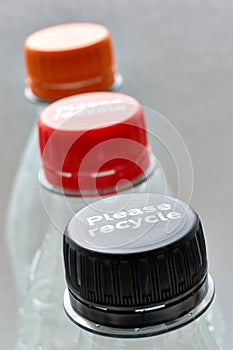 Plastic bottles and bottle caps with please recycle
