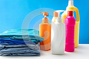 Plastic bottles of cleaning products set on white table