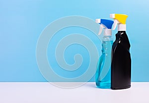 Plastic bottles for cleaning spray gun on blue background