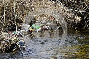 Plastic bottles and garbage in the creek water