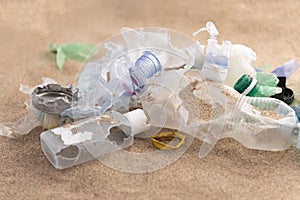 Plastic bottles lies on the beach and pollutes the sea