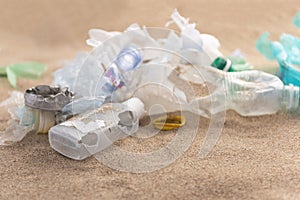 Plastic bottles lies on the beach and pollutes the sea