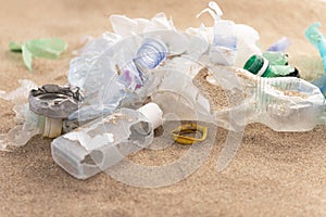 Plastic bottles lies on the beach and pollutes the sea. Spilled garbage on the beach