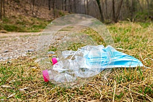 Plastic bottles and mask thrown away in the envirnoment.