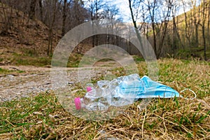 Plastic bottles and mask thrown away in the envirnoment.