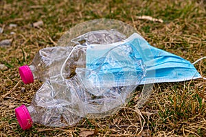 Plastic bottles and mask thrown away in the envirnoment.