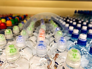 Plastic bottles with mineral water. Closeup on water bottles in raw and lines. Plastic bottles, colorful caps. Plastic bottles wit