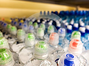 Plastic bottles with mineral water. Closeup on water bottles in raw and lines. Plastic bottles, colorful caps. Plastic bottles wit