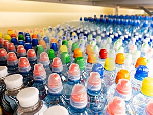 Plastic bottles with mineral water. Closeup on water bottles in raw and lines. Plastic bottles, colorful caps. Plastic bottles wit