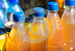 Plastic bottles of orange juice in the market. Close up