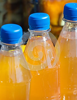 Plastic bottles of orange juice in the market. Close up