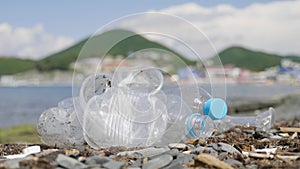 Plastic bottles and other trash on sea beach. Empty used dirty plastic bottles. Environmental pollution and ecological