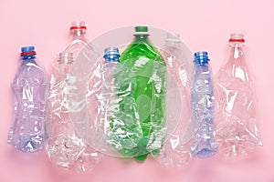 Plastic bottles on pink pastel background top view. Eco plastic recycling