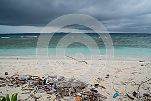 Plastic bottles and plastic bags and crap at dirty beach near ocean at the tropical island