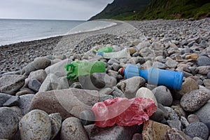 Plastic bottles rotting on beach, North Wales, UK