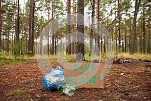 Plastic bottles  in trash bags in forest background. Ecology concept