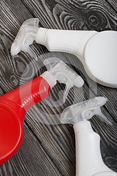 Plastic bottles of white and red color with a spray gun. Cleaning spray. Against a background of painted boards