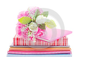 Plastic bouquet on a lovely gift and notebook isolated on white