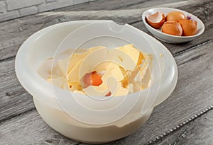 Plastic bowl with butter, egg yolk and flour to be mixed. Cake p