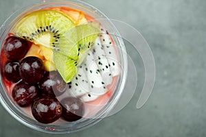Plastic bowl yogurt smoothie with fresh fruits, Kiwi, grape and dragon fruit slice