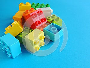 Plastic bricks, blocks toy on bright blue background.