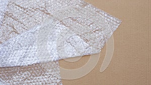 Plastic bubble wrap on cardboard paper sheet background