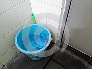 A Plastic bucket in the corner bathroom