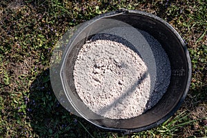 Plastic bucket with organic fertilizer in the garden.