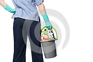 Plastic bucket with wet cleaning products in the hands of a girl in a maid costume from the back