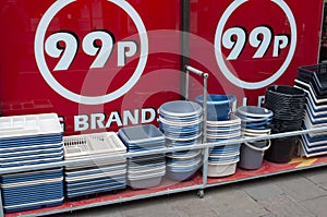 Plastic buckets and kitchenware on display outside a budget store.