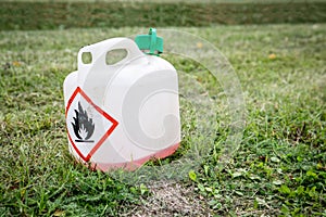 Plastic can in cut grass. Fire danger sign