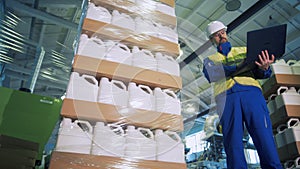 Plastic canisters are getting wrapped into polyethylene under worker`s control