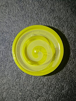 Plastic cap yellow from a PET bottle, with a winning competition code YF2JNH