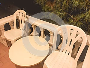 Plastic chairs on the balcony in the hotel. outdoor furniture, outdoor recreation. table and two chairs for relaxation. fenced