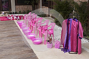 Plastic chairs with punch bowls arranged to do foot treatments for girls; spa theme children`s party