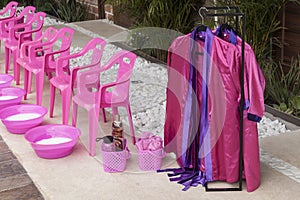 Plastic chairs with punch bowls arranged to do foot treatments for girls; spa theme children`s party