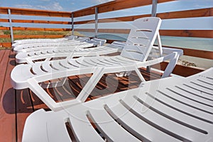 Plastic chaise lounges stand near the pool