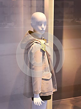 Plastic child mannequin behind a fashion store window