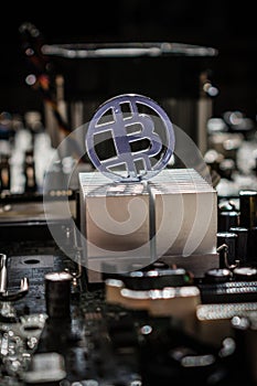 Plastic clear bit coin with motherboard and electronic background and aluminum cooler