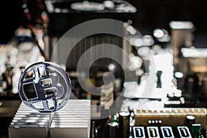 Plastic clear bit coin with motherboard and electronic background and aluminum cooler